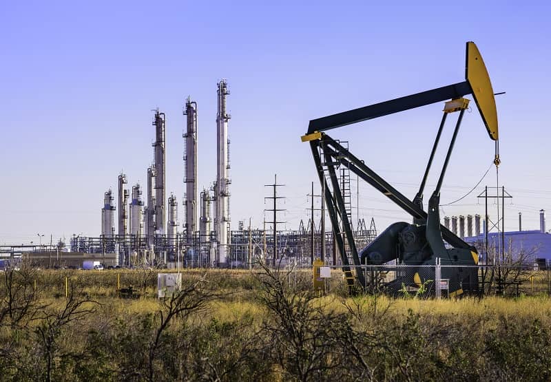 Pumpjack (oil derrick) and refinery plant in West Texas-cm